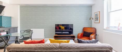 A modern living room with a sofa, a coffee table, and a television.