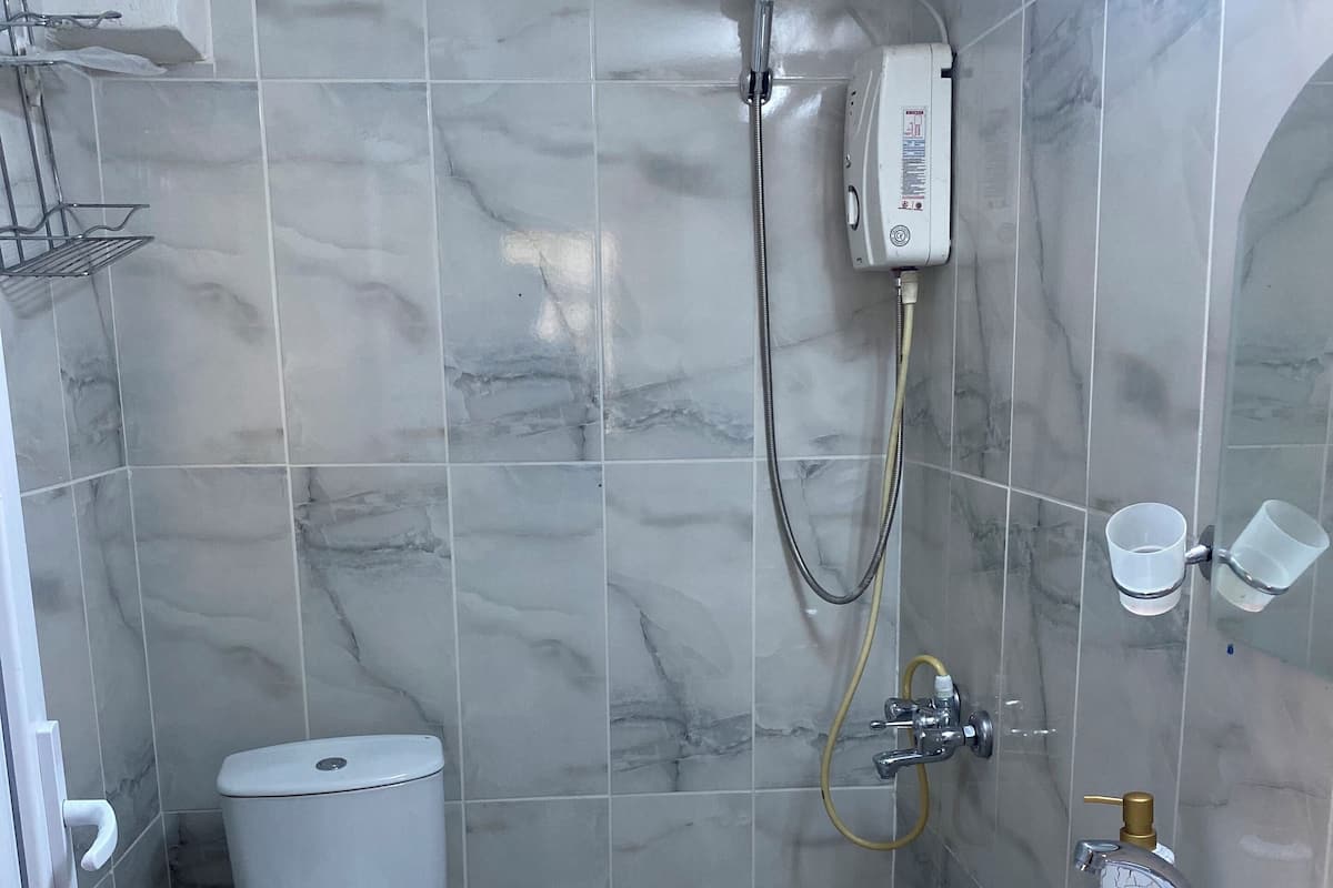 Une salle de bain avec des toilettes, une douche et un lavabo.