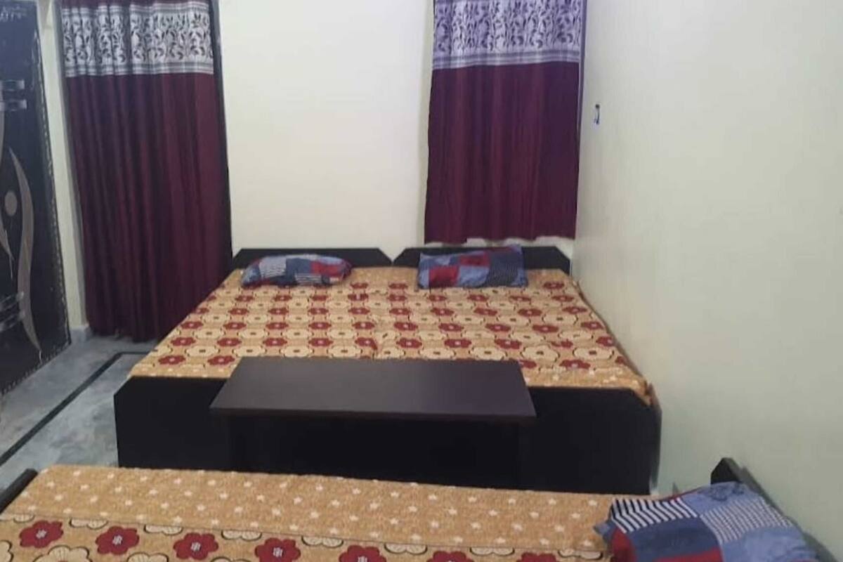 A bedroom with a bed, a bedside table, and curtains.