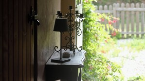 En trädör som fører til en have med et lille bord og en lampe.