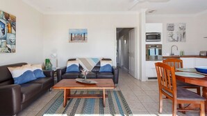 Un salon comprenant un canapé, une table basse et un coin repas avec des chaises et une table.
