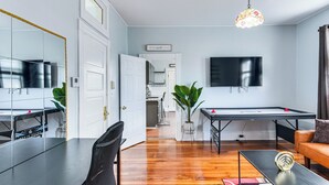 A modern living room with a pool table, a television, and a dining area with a chair and table. - Pet-friendly Stoughton Apartment w/ Outdoor Space (Stoughton)