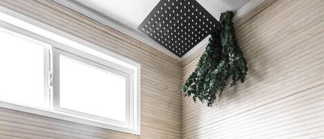 A bathroom with a shower, a window, and a wall-mounted showerhead.