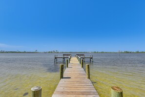 A wooden pier extending into a calm body of water with clear skies above. - Pool & Beach Access: Lovely Mary Esther Condo! (Mary Esther)