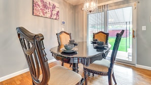 A dining area with a round table, chairs, and a chandelier. - 7 Mins to DTW - Comfortable Inkster Home (Inkster)
