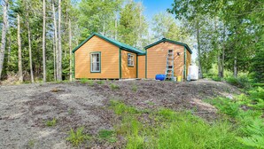 Two wooden cabins in a forest setting with a clear sky. - Harrington Cabin w/ Grills - Near Beaches & Hiking (Harrington)