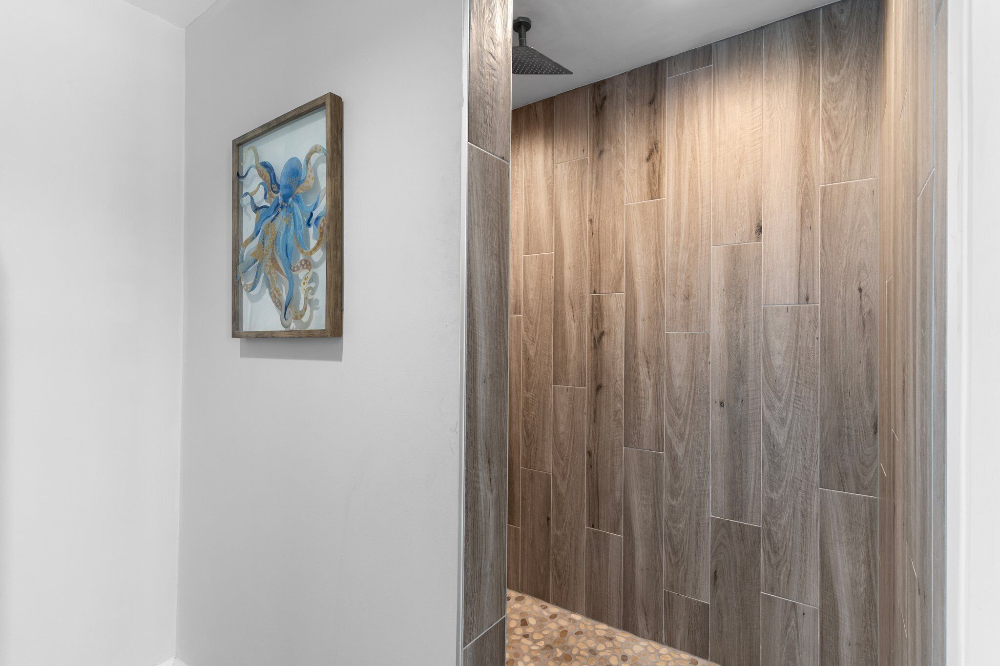 A bathroom with wooden paneling and a framed artwork on the wall.