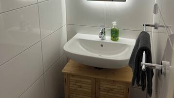 Een haardroger, handdoeken, zeep, toiletpapier