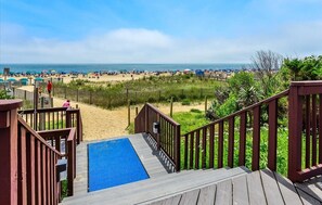 A wooden deck leading to a pool with a view of a beach and ocean. - Updated 2 BR 2 BA with Indoor Pool in Ocean Front Building (Ocean City)