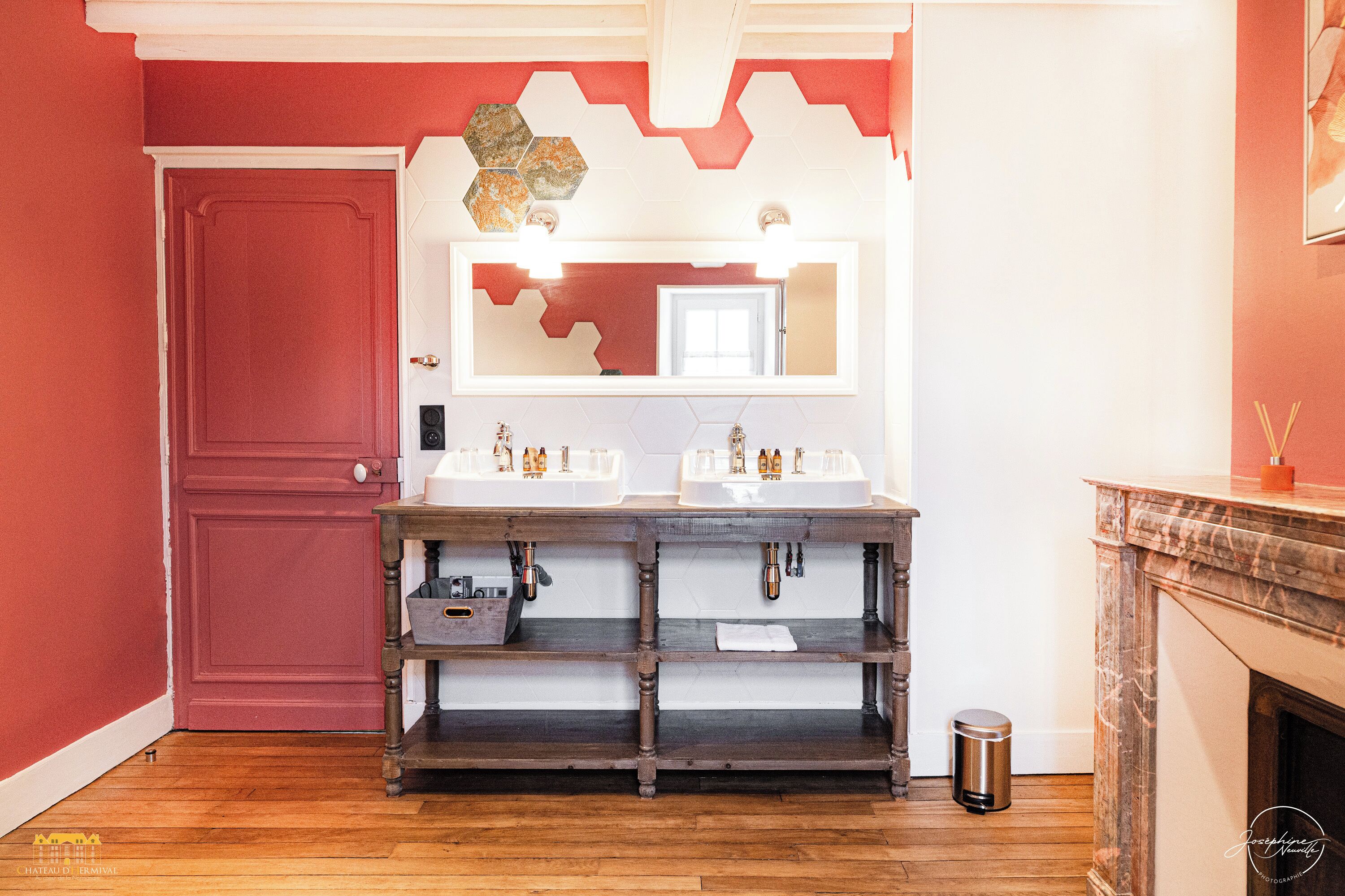 A bathroom with two sinks, a mirror, and a wooden vanity.