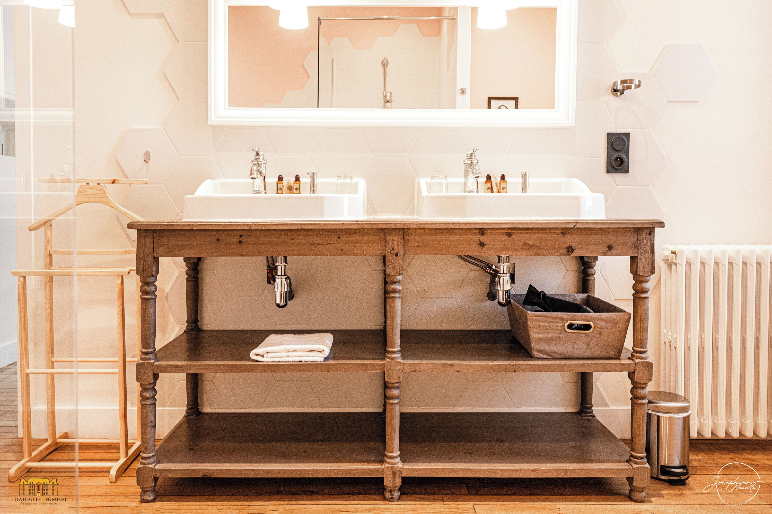 Une salle de bain avec deux lavabos, un meuble-lavabo en bois et un miroir.