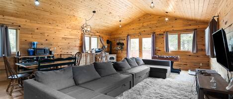 【Upper-Level Great Room】 Gathering space off the deck — stove anchors the far wall
