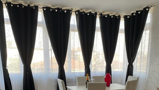 A room with a black sofa, a dining table with chairs, and large windows with black curtains. - Like At Home Venice Mestre, bright, family and private parking place. (Venezia)