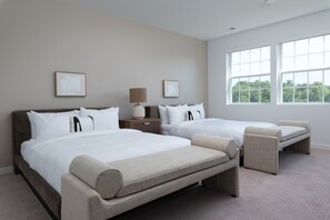 Une chambre d’hôtel avec deux lits, une table de chevet, une lampe et de grandes fenêtres.