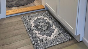 Eine kompakte Küche mit weißen Schränken, einer Granit Arbeitsplatte, einer eingebauten Mikrowelle und einem Edelstahl-Spülbecken.