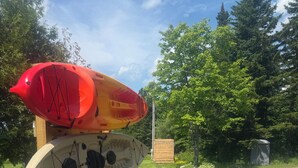 A stack of kayaks on a grassy area beside a gravel path. - Peaceful camp with breathtaking views (Westmore)