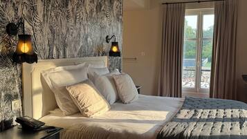 Une chambre à coucher avec un grand lit, deux lampes de chevet, un téléphone et une fenêtre avec des rideaux.