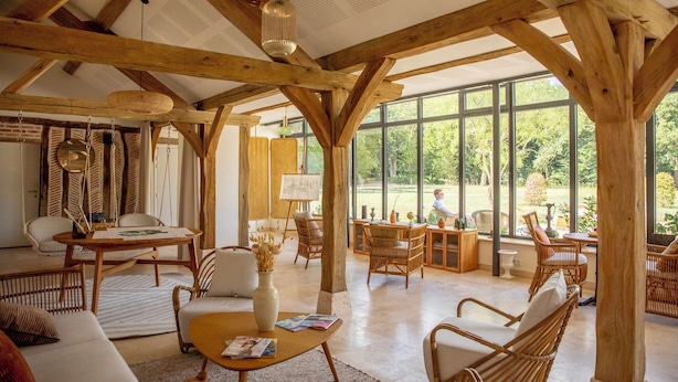 A spacious room with wooden beams, large windows, and wicker furniture. - Les Hayes en Sologne (Fontaines-en-Sologne)