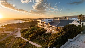 A coastal house with a balcony overlooking the beach, a staircase leading to the entrance, and a view of the ocean. - Absolute Ocean Frontage 1 The Strand Pt Elliot (Port Elliot)