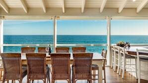 A dining area with wicker chairs and a table, overlooking the ocean. - Absolute Ocean Frontage 1 The Strand Pt Elliot (Port Elliot)