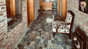 A hallway with a patterned floor, wooden doors, and a mirrored wall. - Moj Dom Küçükköy (Ayvalik)