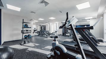 A modern gym with treadmills, weight machines, and exercise balls.