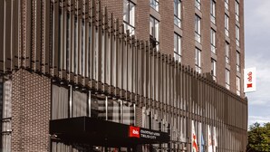 A tall brick building with a modern facade, a prominent 'ibis' sign, and a glass entrance. - Ibis Tbilisi City (Tbilisi)