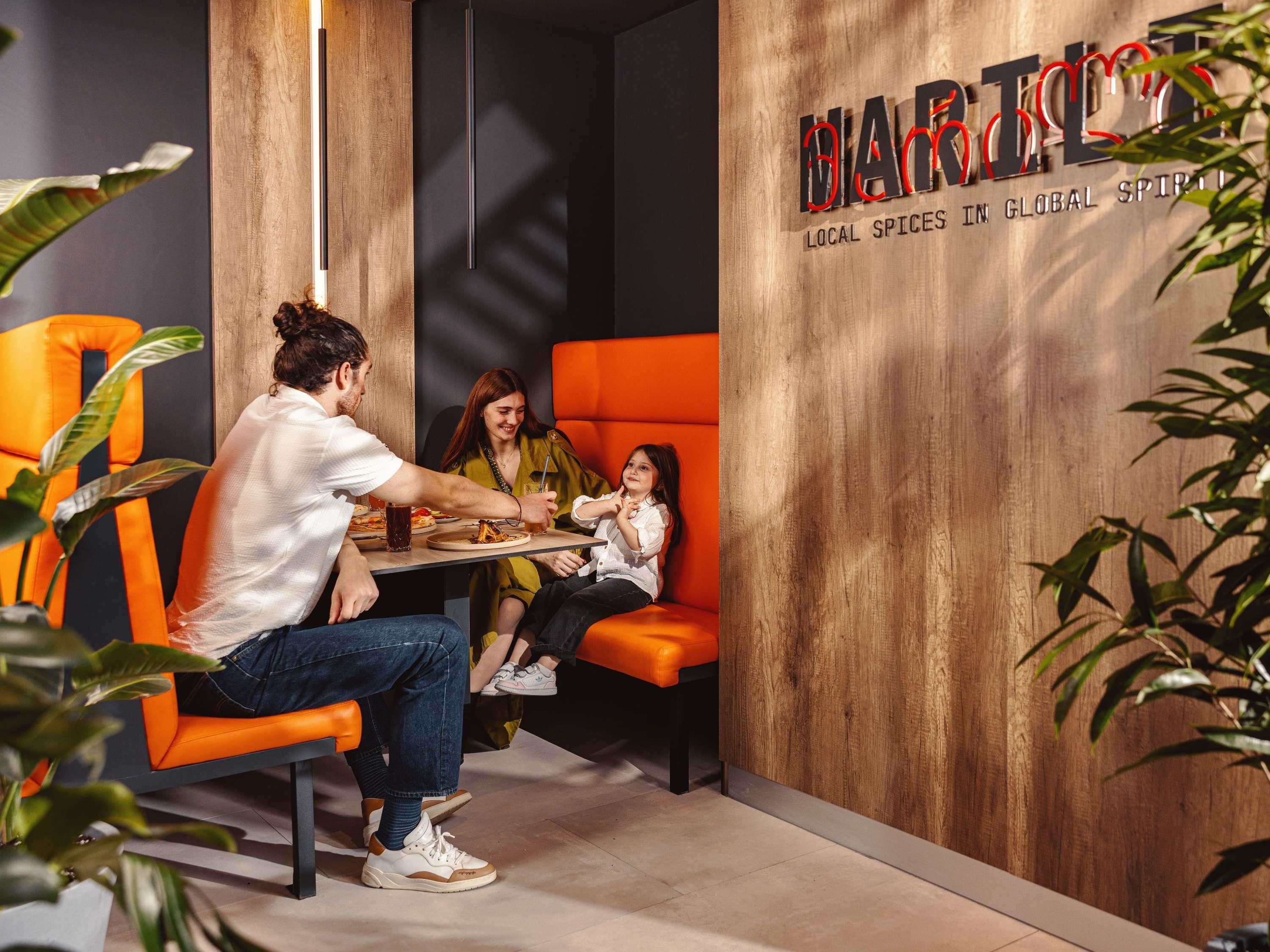 A modern interior with a wooden accent wall, a table with food, and seating arrangements.