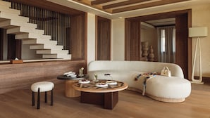 A modern living room with a staircase, a round coffee table, a sofa, and a lamp. - Royal Mansour Tamuda Bay (M'diq)