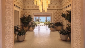 A hallway with patterned walls, potted plants, and a view to the outside. - Royal Mansour Tamuda Bay (M'diq)