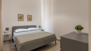 A modern bedroom with a bed, bedside tables, and a small desk. - La Casa sul Mercato by Wonderful Italy (Palermo)