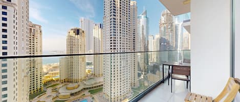 A high-rise building with a glass balcony overlooking a cityscape.