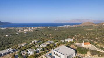 A coastal residential area with modern houses, a small church, and a clear view of the sea.