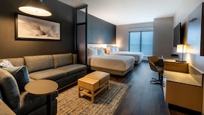 A modern hotel room with a sofa, two single beds, a desk, and a large window. - Hyatt Place Eagle Pass (Eagle Pass)