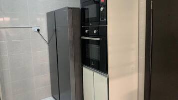 Deluxe Apartment, City View | Private kitchen | Fridge, microwave, cookware/dishes/utensils