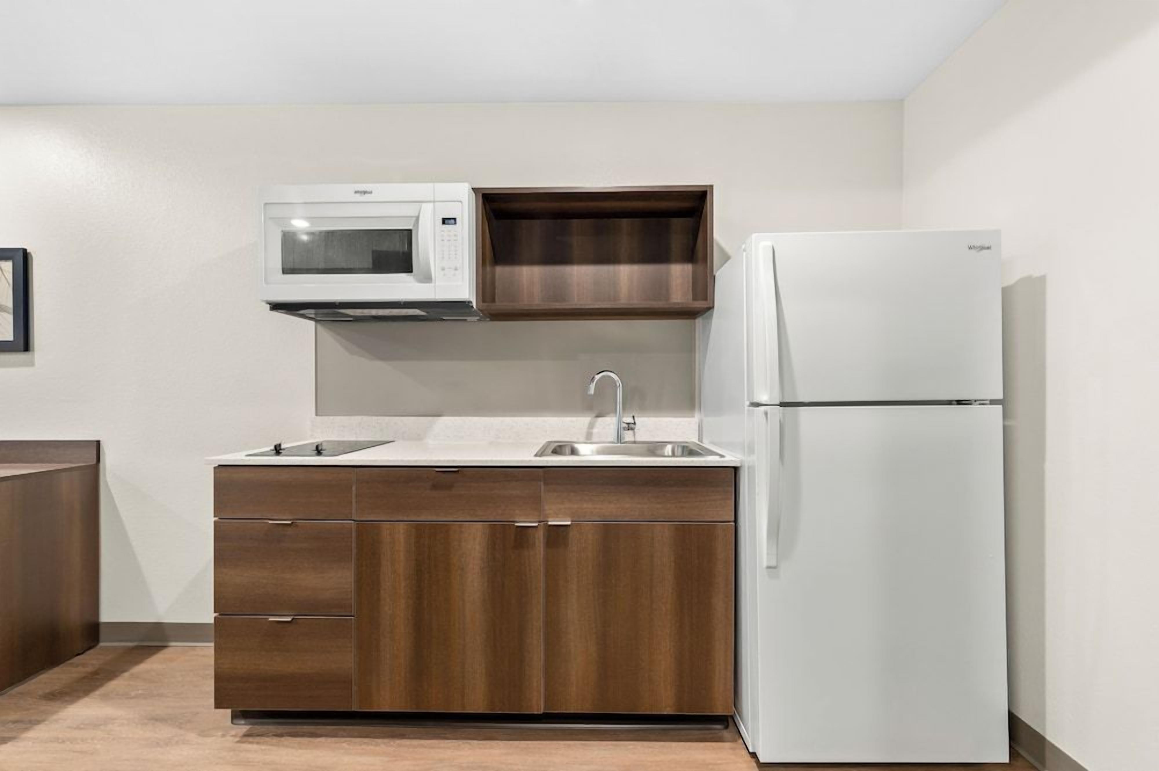 A compact kitchen with a microwave, sink, and refrigerator.