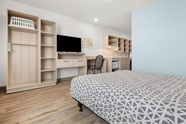 Un dormitorio con cama, escritorio, silla y estanterías empotradas.