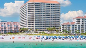 A multi-story hotel with balconies, located near a beach with umbrellas and people. - 1411 The Tides at Tops'l - Gulf Front, Community Pool, & Kiddie Pool (Miramar Beach)