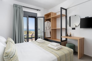 Ein Hotelzimmer mit einem Bett, einem Holzschrank, einem Schreibtisch, einem Spiegel und einem Fernseher.