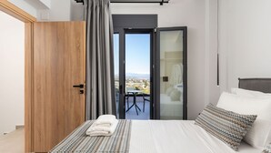 A bedroom with a bed, a view of the city, and a balcony. - Villa Aelia - With Private Pool and Sauna (Rethymno)