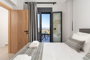 Ein Schlafzimmer mit Bett, Blick auf die Stadt und einem Balkon.