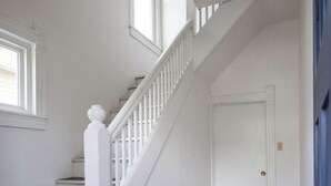 A white staircase with a balustrade leading to a closed door. - Walkable to Everywhere in Little Italy- Near CWRU, Cleveland Clinic Main Campus  (Cleveland)