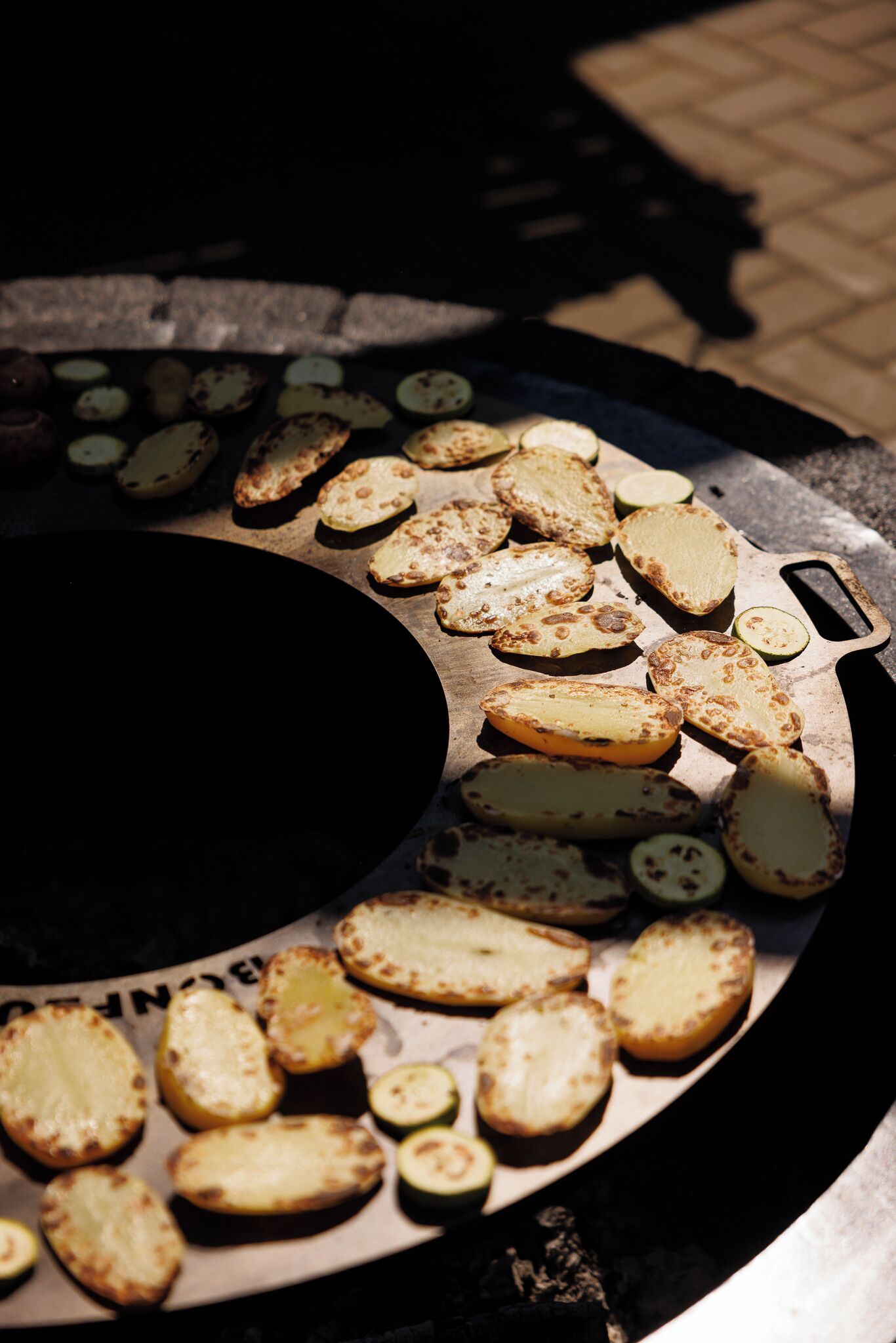 En grill med olika sorters grönsaker och potatis.