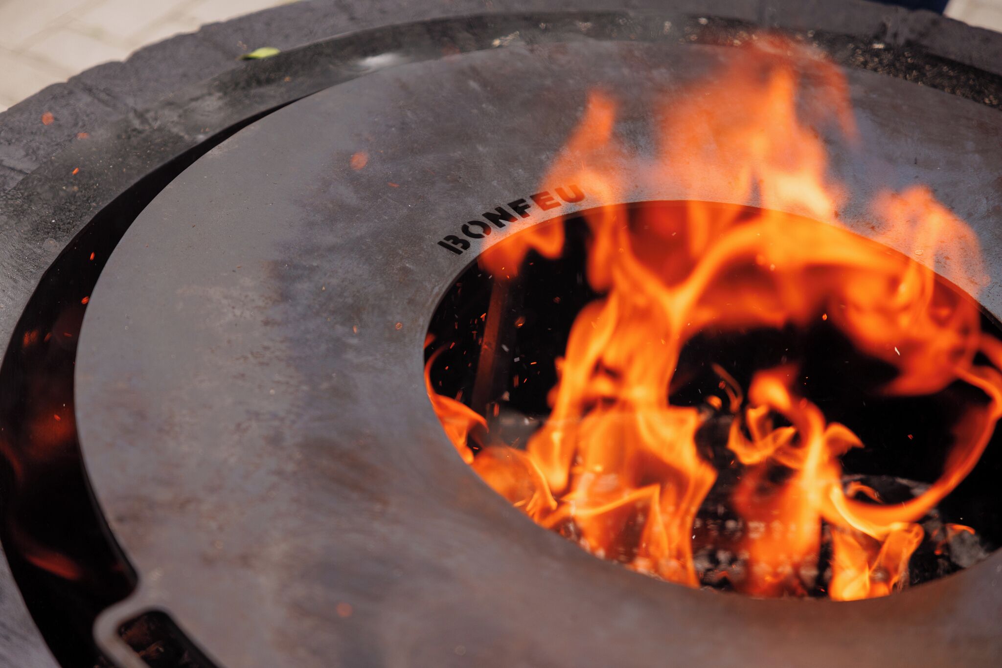 A circular fire pit with the brand name "BONFEO" visible on its side.