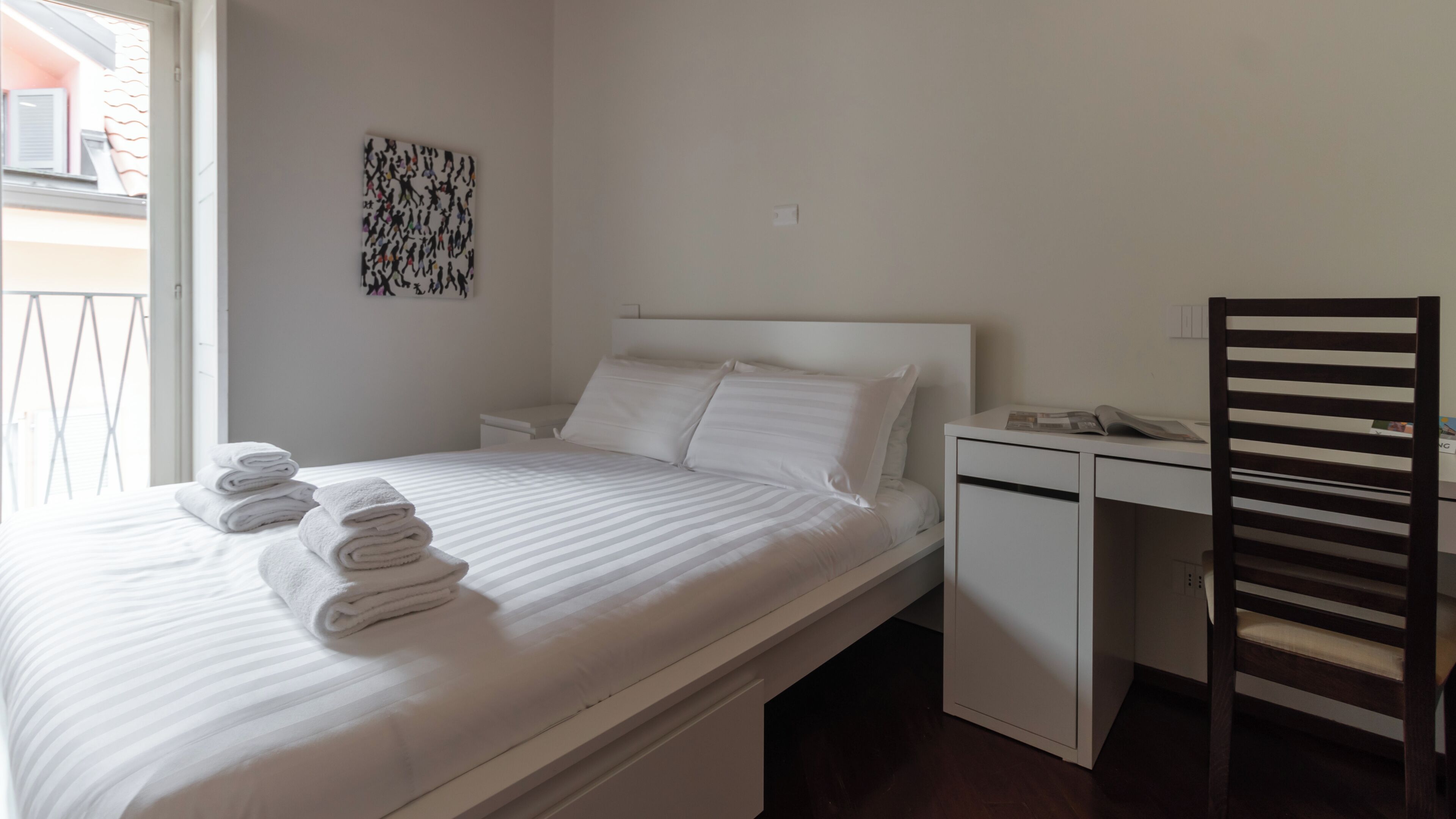Una habitación de hotel con una cama, un escritorio y una silla.