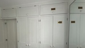Un conjunto de puertas dobles blancas con una rejilla central y pequeñas rejillas en cada puerta.