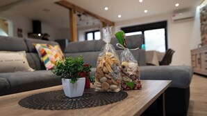 A modern living room with a wooden coffee table, a potted plant, and two glass jars of cookies.