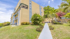 Um hotel com vários andares, pátio central, galeria coberta e vegetação exuberante.