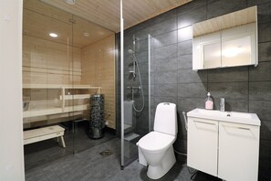 Un bagno moderno con cabina doccia in vetro, un water bianco e un mobile lavabo con specchio.