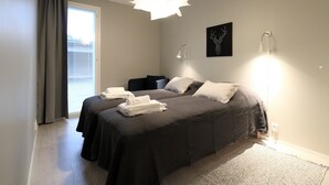 A bedroom with a bed, bedside lamps, a window with curtains, and a wall-mounted artwork. - Forenom Serviced Apts Espoo Perusmäki 2 (Espoo)